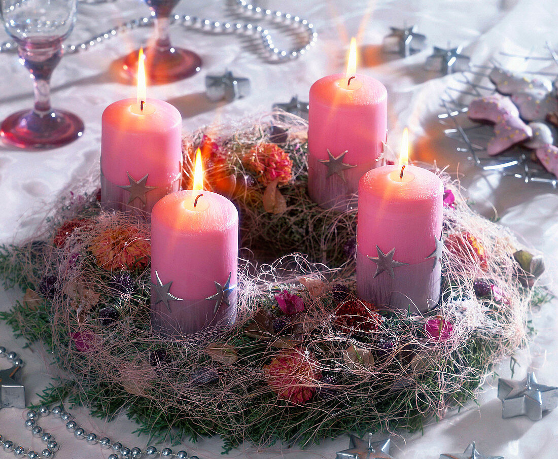 Kranz aus Tannenzweigen und rosa Kerzen
