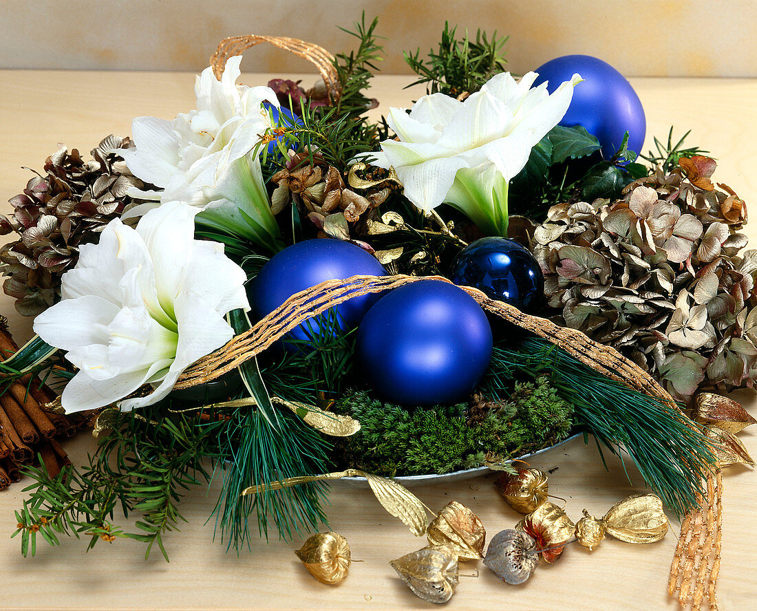 Arrangement of amaryllis flowers, greenery & Christmas baubles