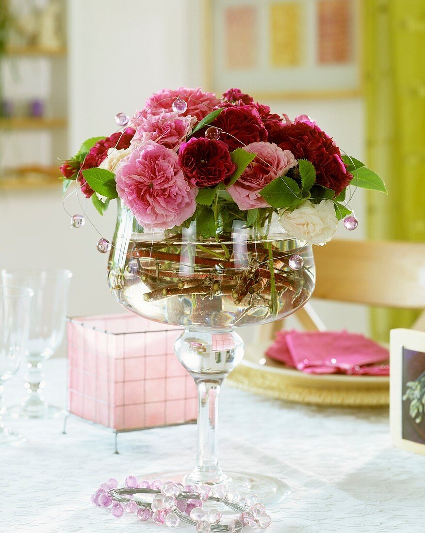 Old roses in a stemmed glass bowl