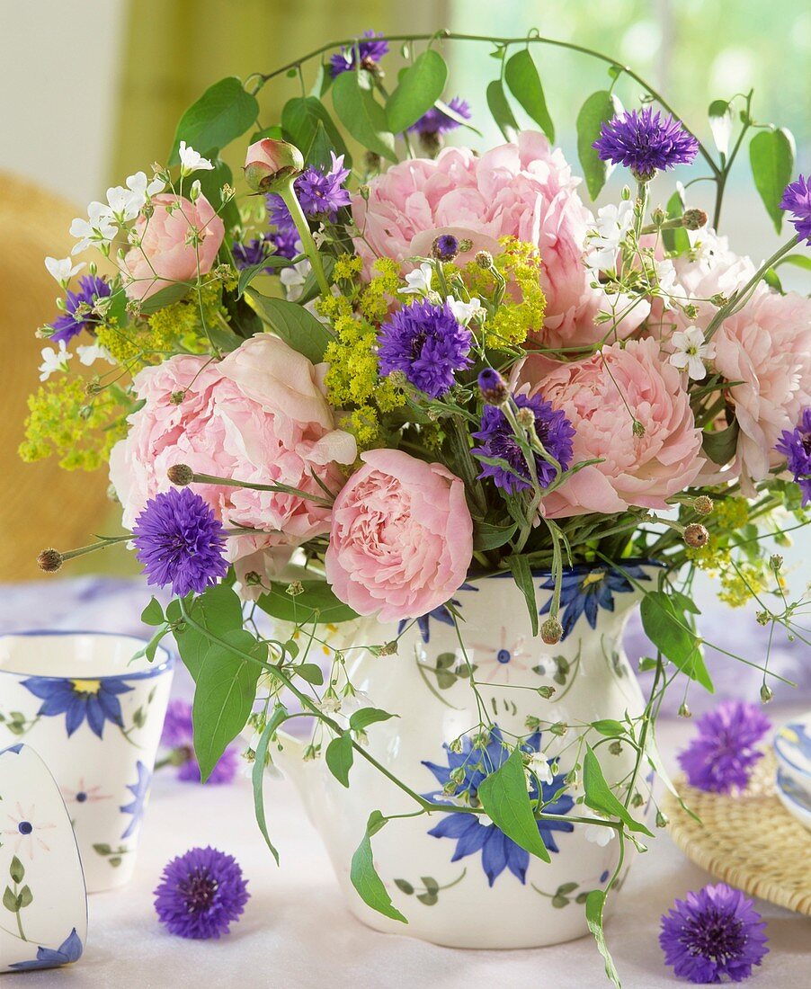 Arrangement of peonies, lady's mantle and cornflowers