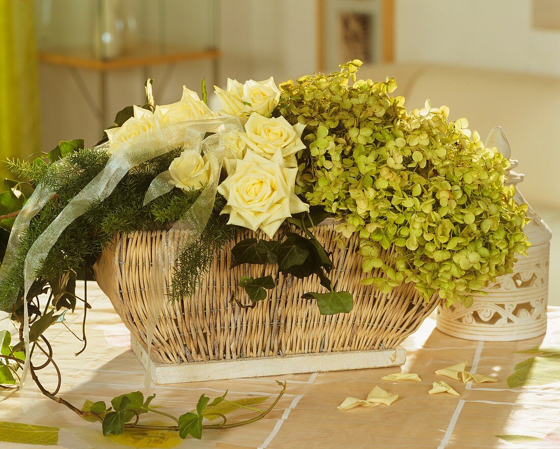 Basket of white roses, asparagus and hydrangeas