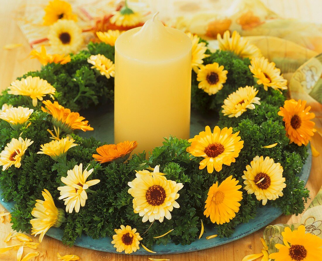 Kranz aus Petersilie und Calendulablüten mit gelber Kerze