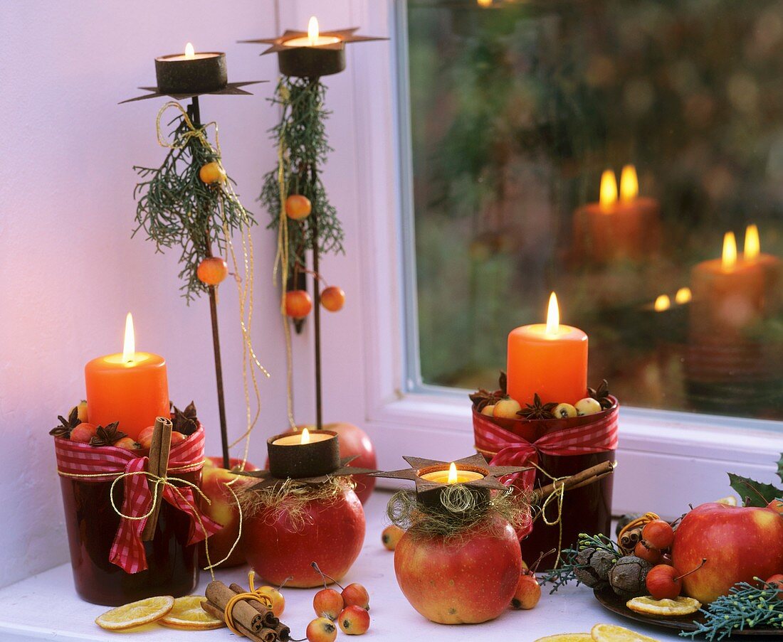 Winter decoration with apples, cinnamon sticks & candles