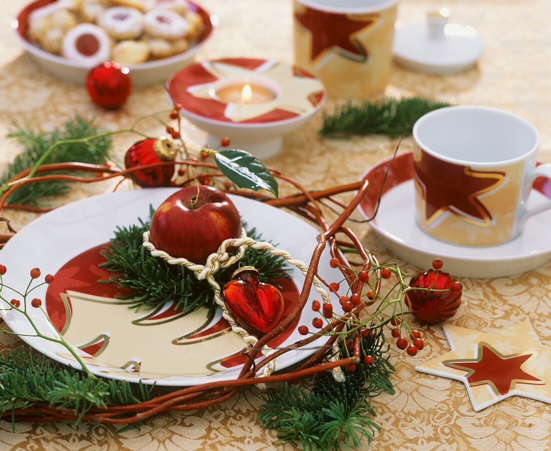 Weihnachtliche Tischdeko mit Apfel und Tannenzweigen