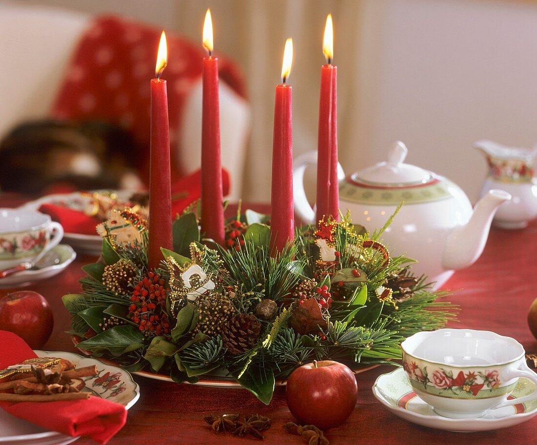 Adventskranz in grün und rot auf weihnachtlichem Teetisch
