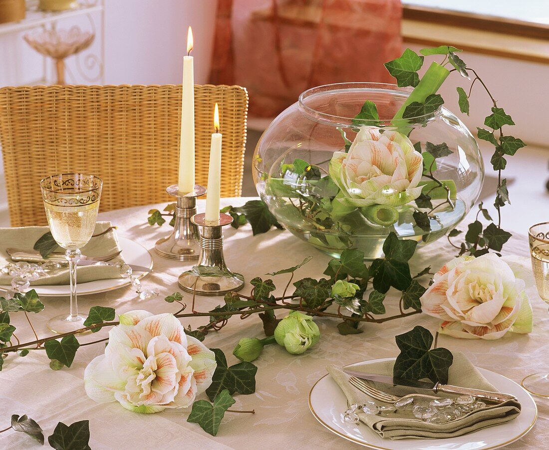 Glaskugelvase mit Amaryllis auf festlich gedecktem Tisch