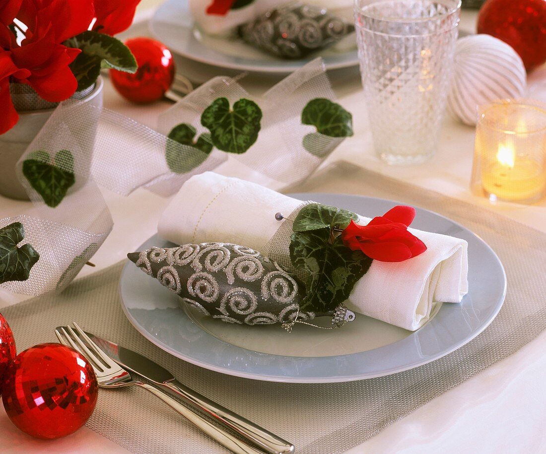 Place setting decorated with red Cyclamen and tree ornament