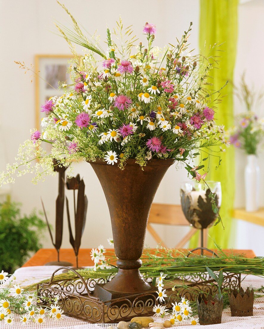 Iron vase of meadow flowers, marguerites, knapweed & grasses
