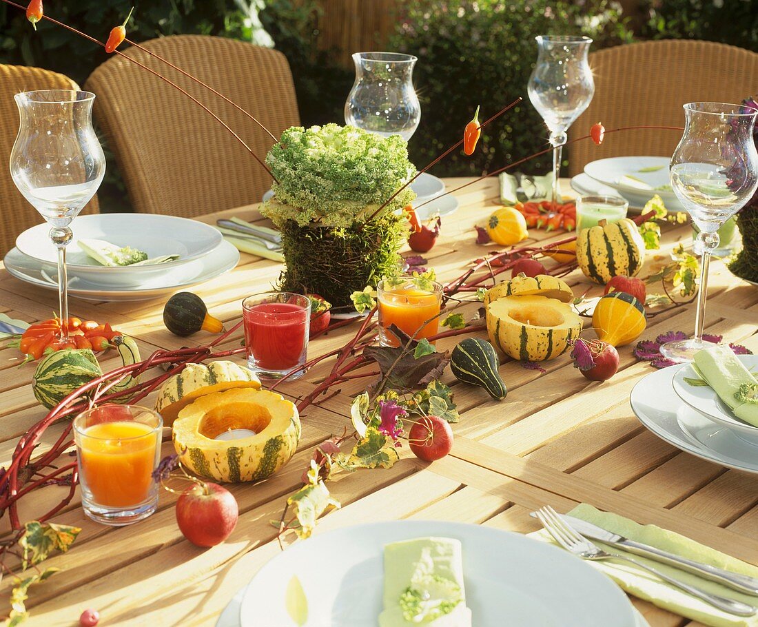 Herbstlich gedeckter Tisch mit Zierkohl und Zierkürbissen