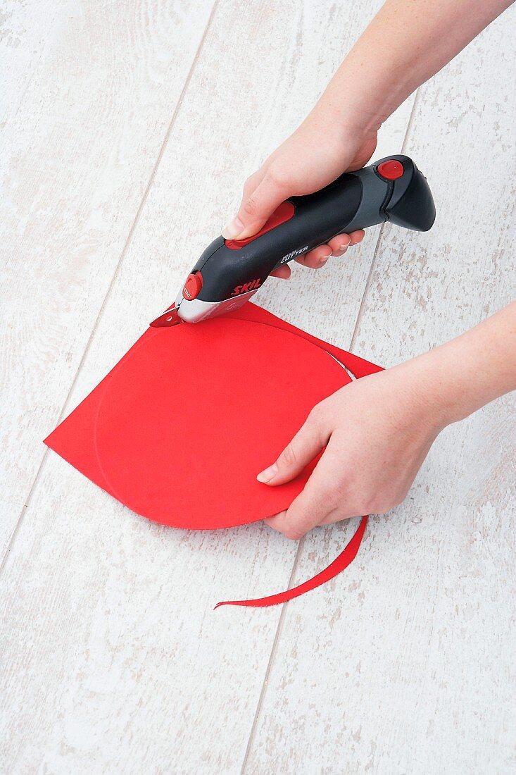 Cutting a circle out of red rubber