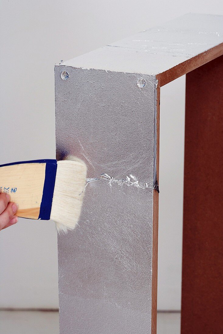 Wandkonsole selber bauen (Aufgeklebte Silberfolie mit Pinsel glatt streichen)