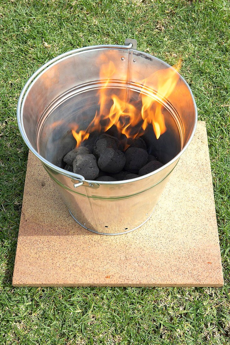 Grilleimer mit brennender Holzkohle