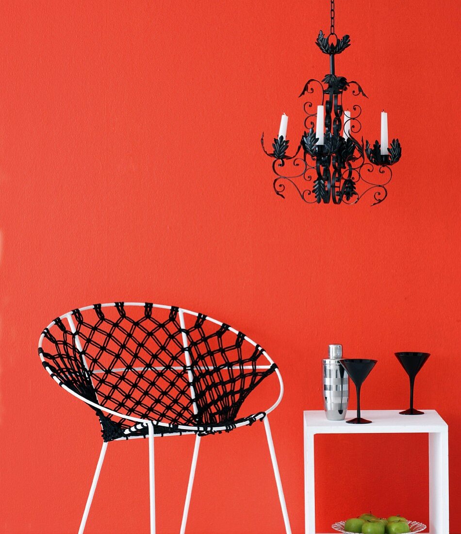 Macramé chair and small table against red wall