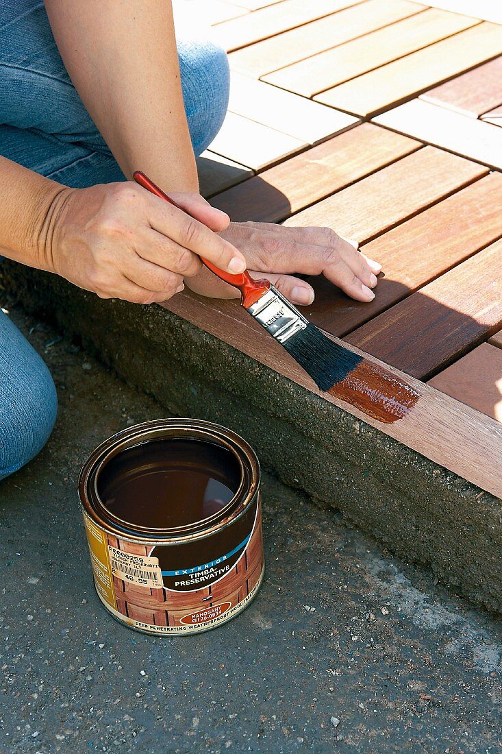 Woman painting wooden edging