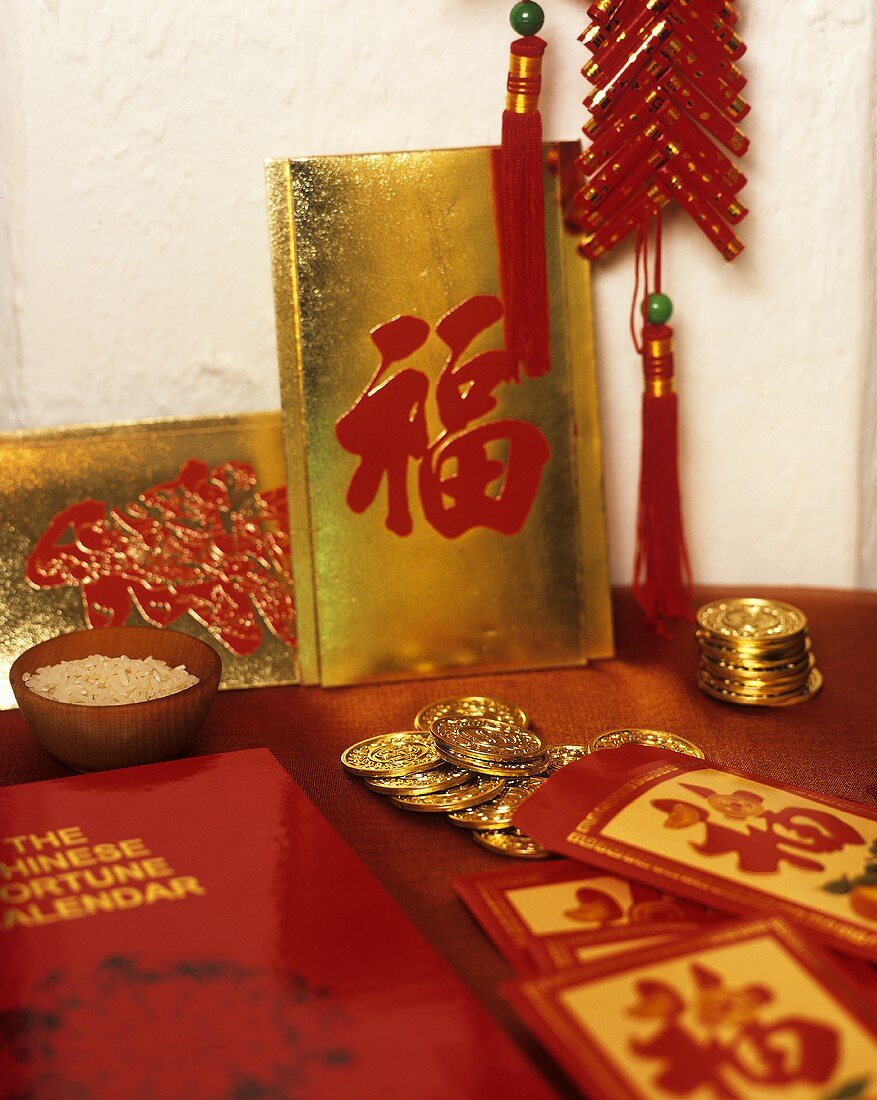 Chinesische Glückssymbole zu Neujahr (Goldmünzen und Reis)