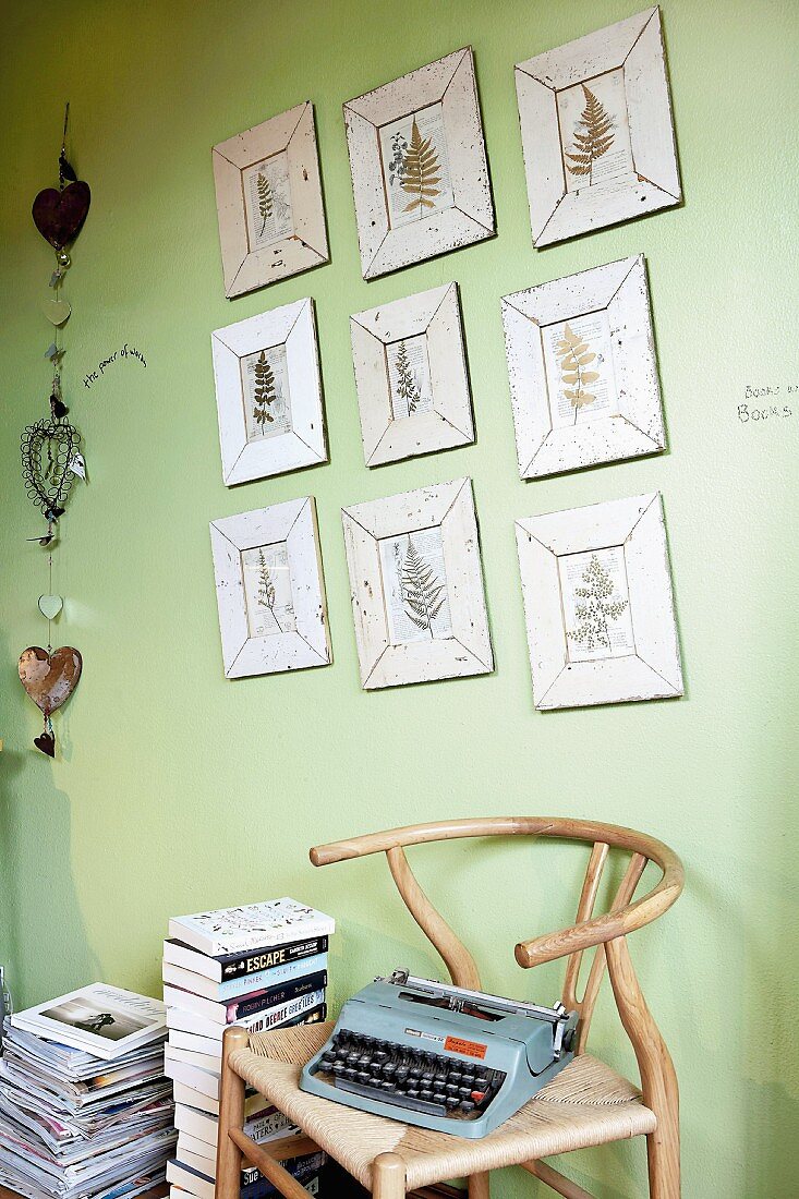 Zimmer mit Wandbildern, Büchern, Stuhl und Schreibmaschine