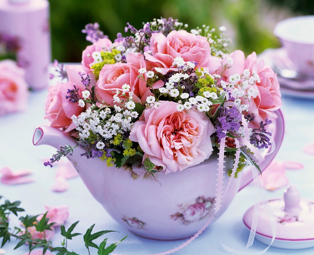 Small posy of pink roses and gypsophila in teapot