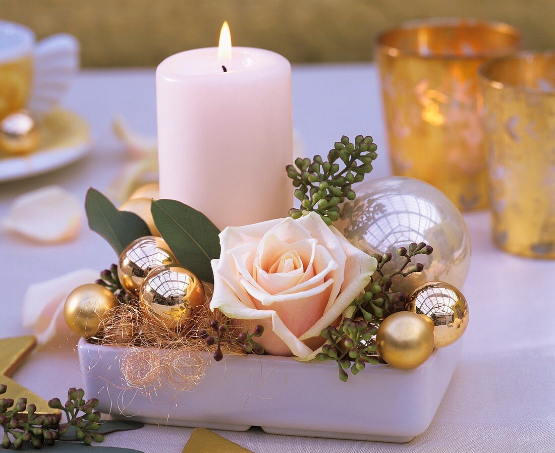 Candle, rose and Christmas baubles in square dish