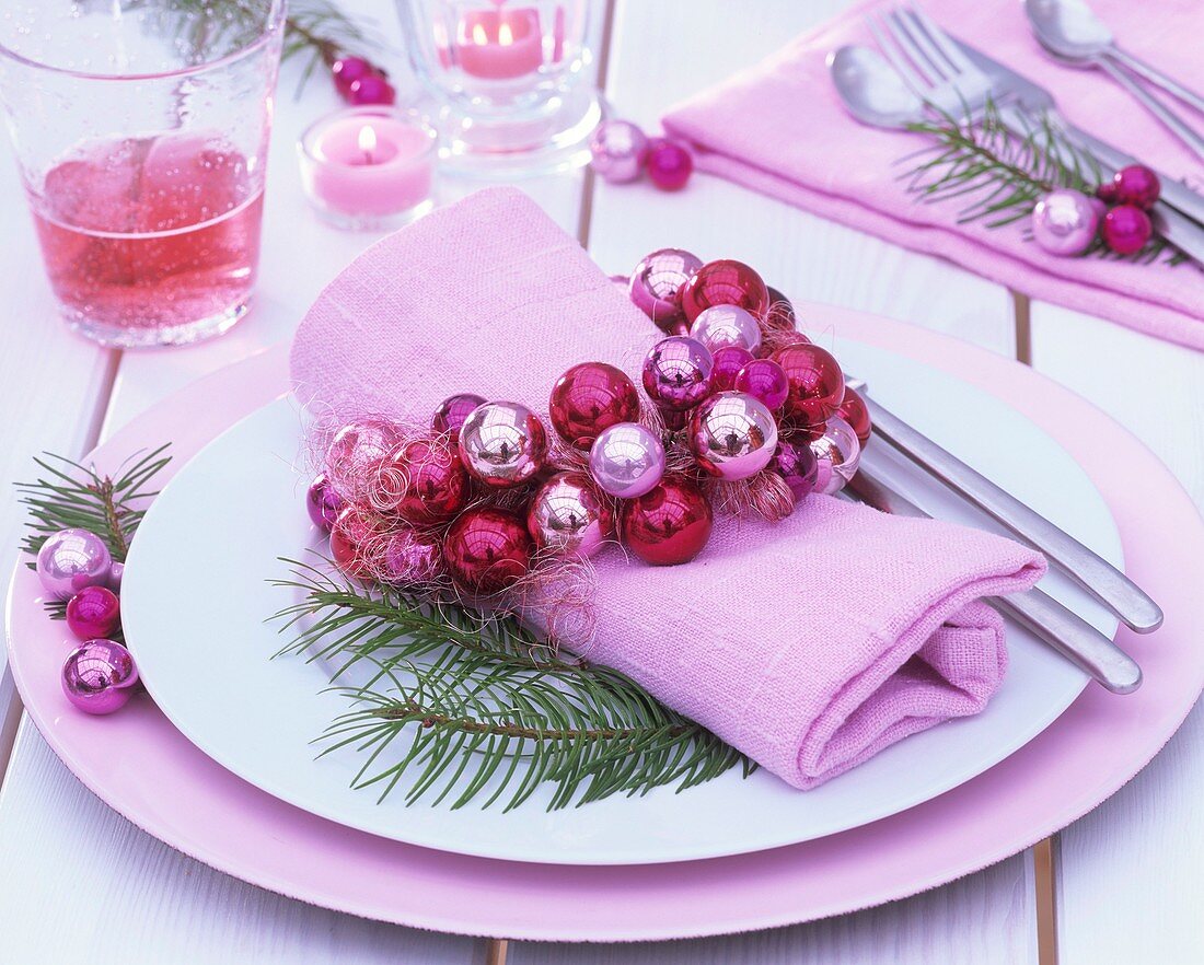 Gedeck mit Serviettenring aus rosa Weihnachtskugeln