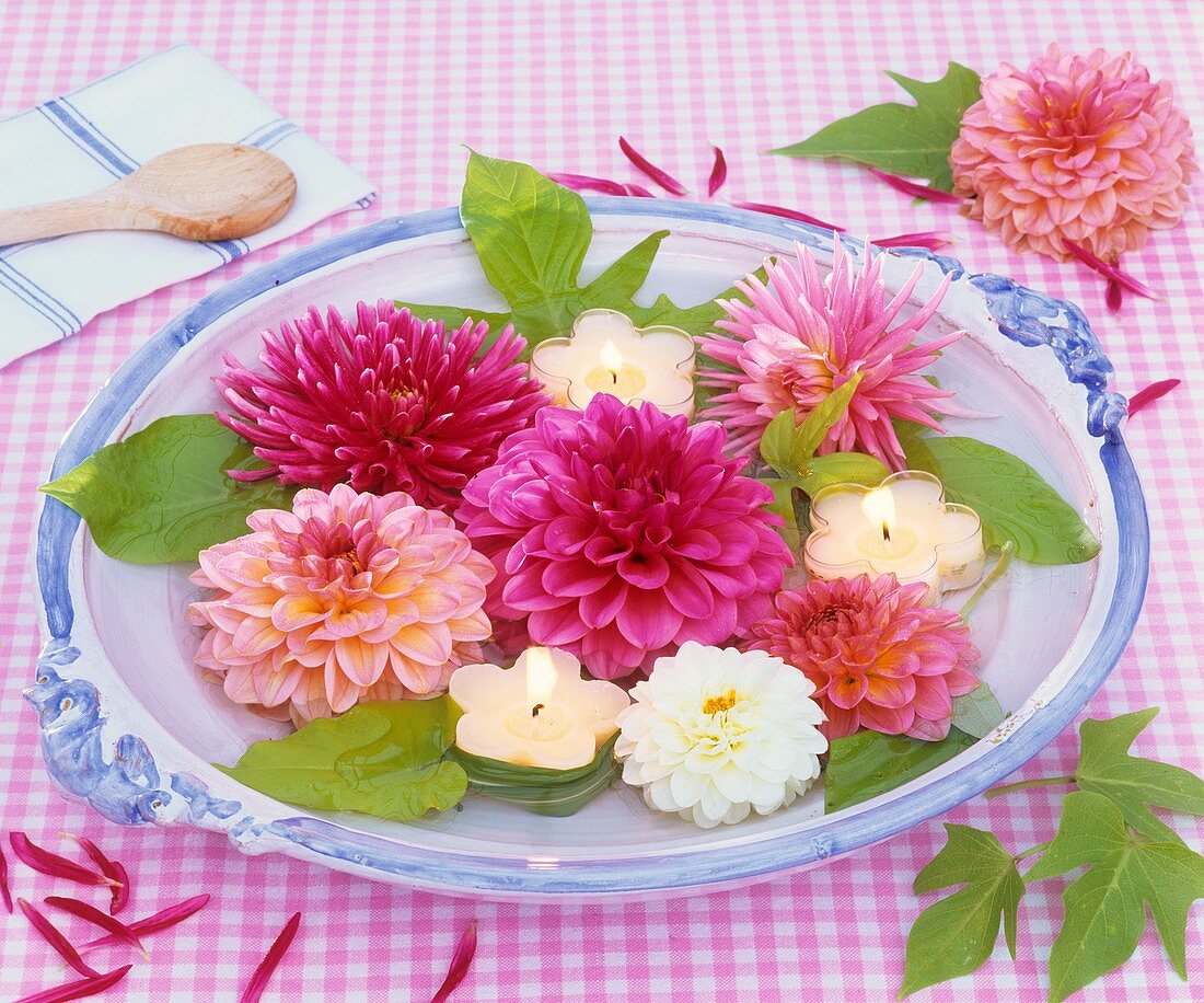 Various types of dahlias & floating candles in bowl of water