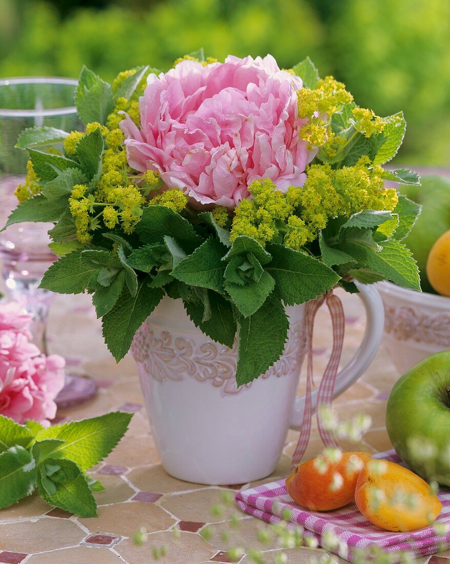 Peony in 'frill' of lady's mantle and peppermint
