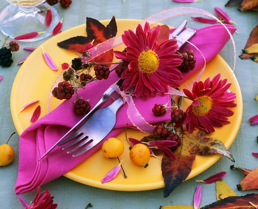 Gedeck mit Herbstchrysanthemen und Zieräpfeln dekoriert