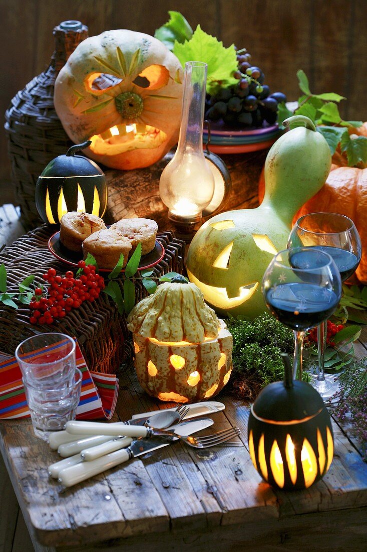 Autumnal arrangement with illuminated pumpkins & red wine