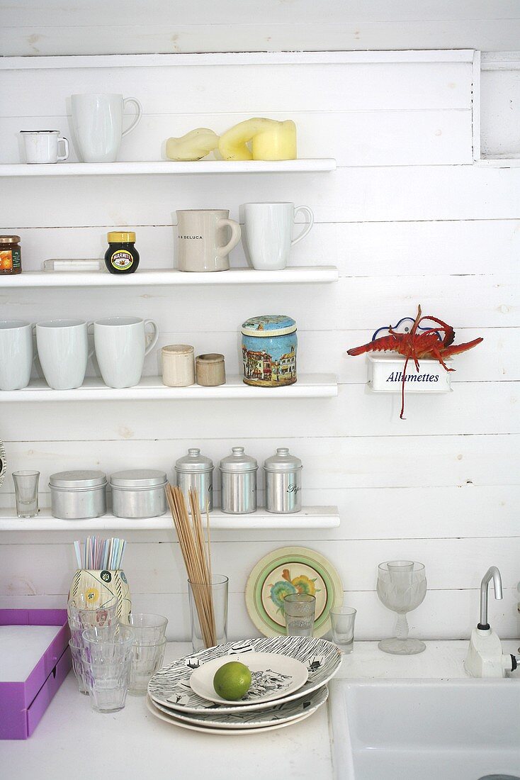 Kitchen utensils on white shelves in a beach house