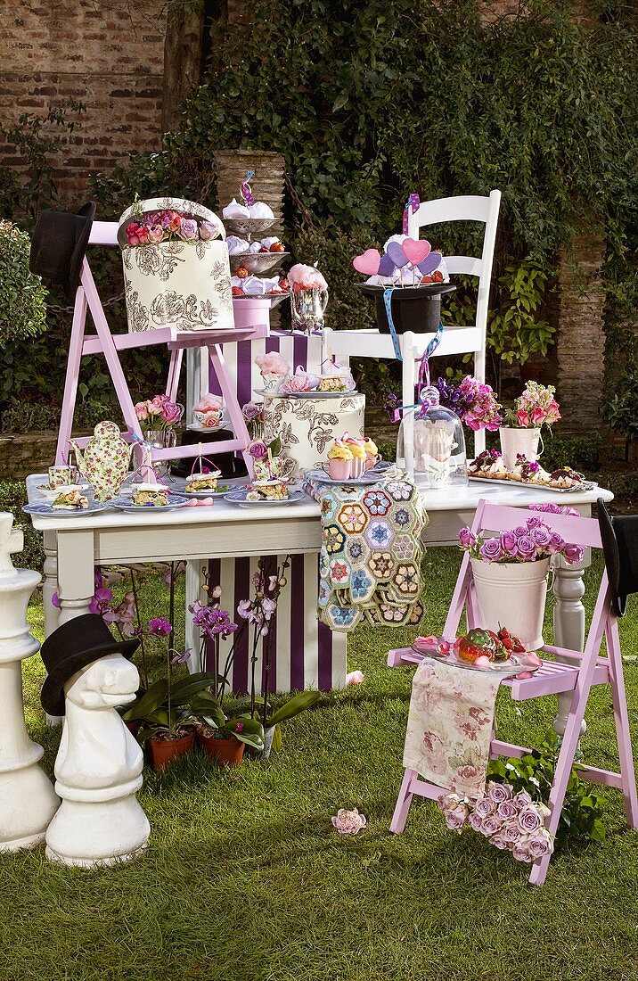 Partytisch mit Häppchen und Blumen für eine Mad Hatter Party