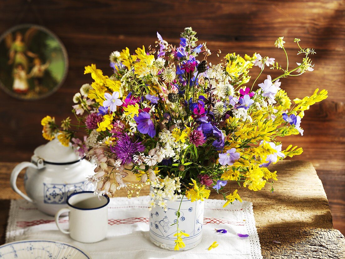 Vase of wild flowers on rustic wooden table