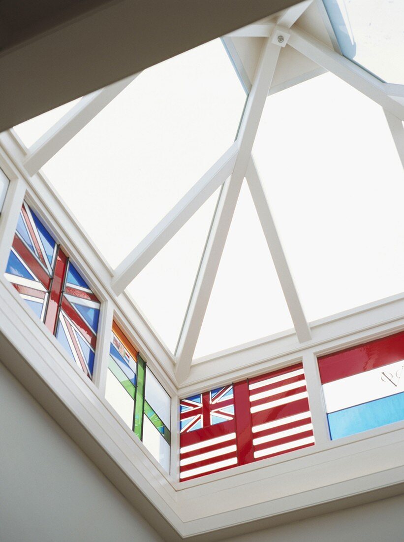 Dachlaterne mit weisser Holzkonstruktion und bleiverglasten Seitenfenstern mit Flaggenmotiven