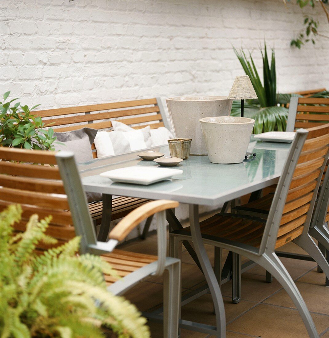 Moderne Gartenmöbel-Garnitur aus Metall und Holz auf einer Terrasse