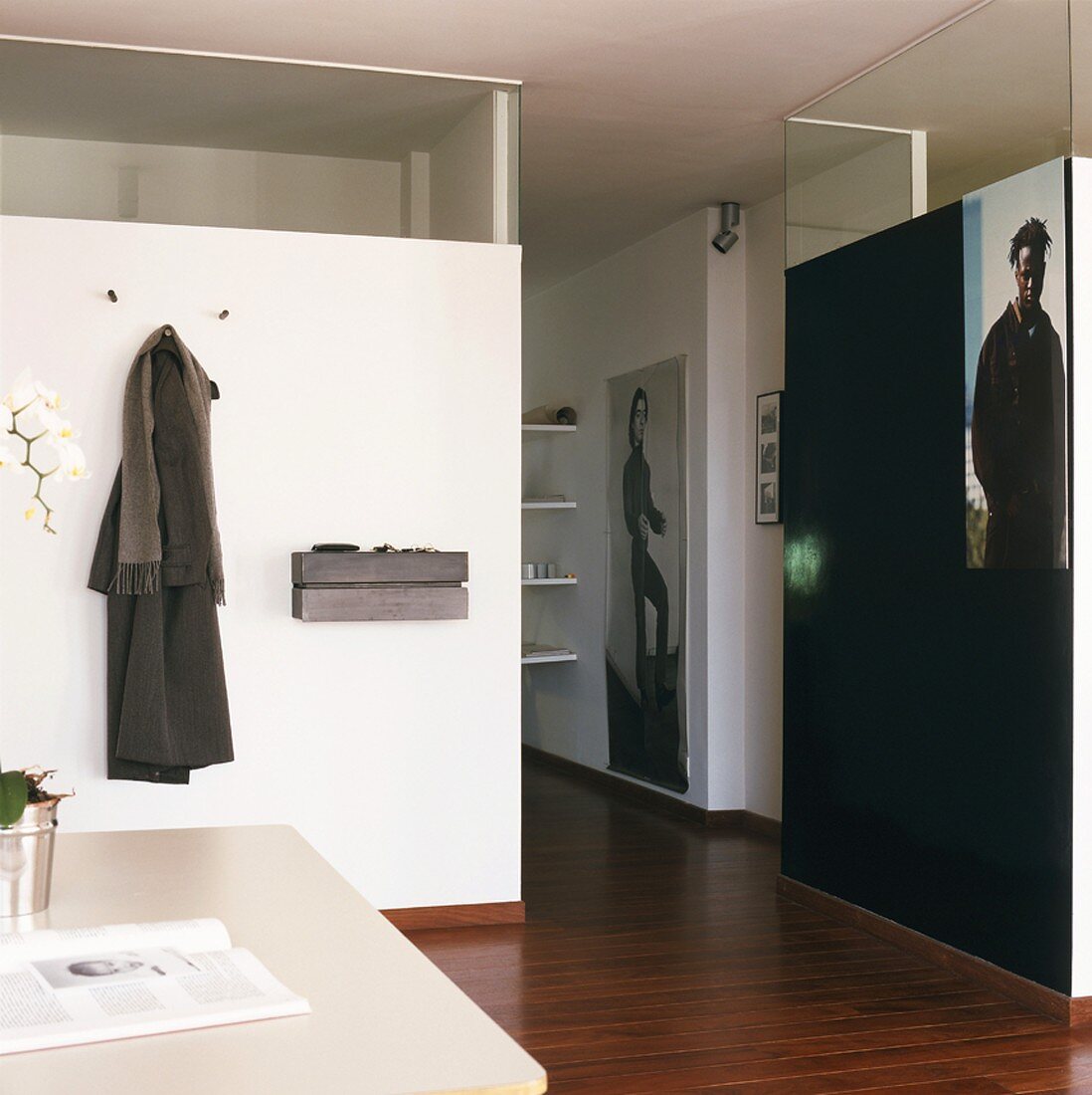 Modern foyer with coat rack and large photos on half-height partition walls