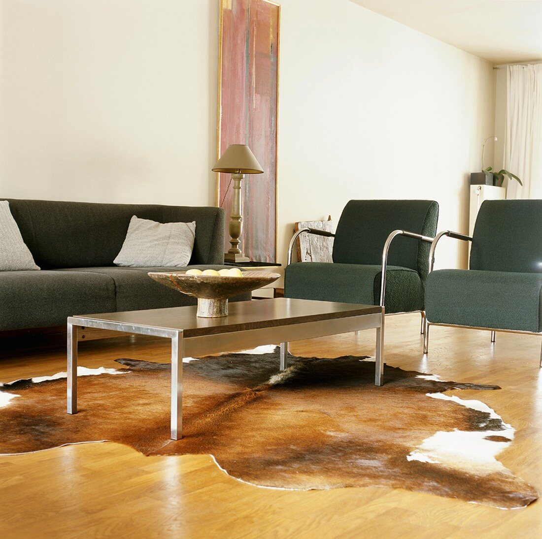 Wohnraum mit Designer Couchgarnitur und modernem Tisch auf Kuhfell