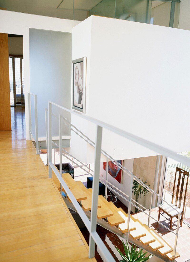 Gangflucht auf der Galerie und Blick auf den offenen Treppenabgang in den Wohnraum eines zeitgenössischen Hauses