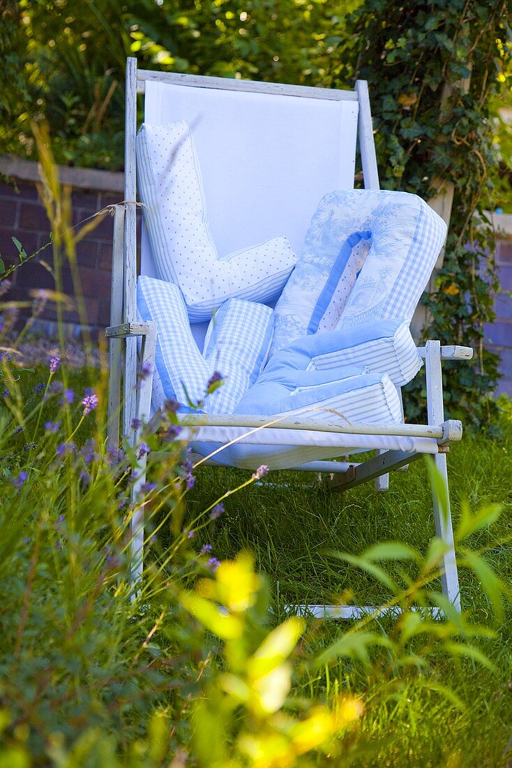 Blauer Liegestuhl im Garten mit Love-Buchstabenkissen