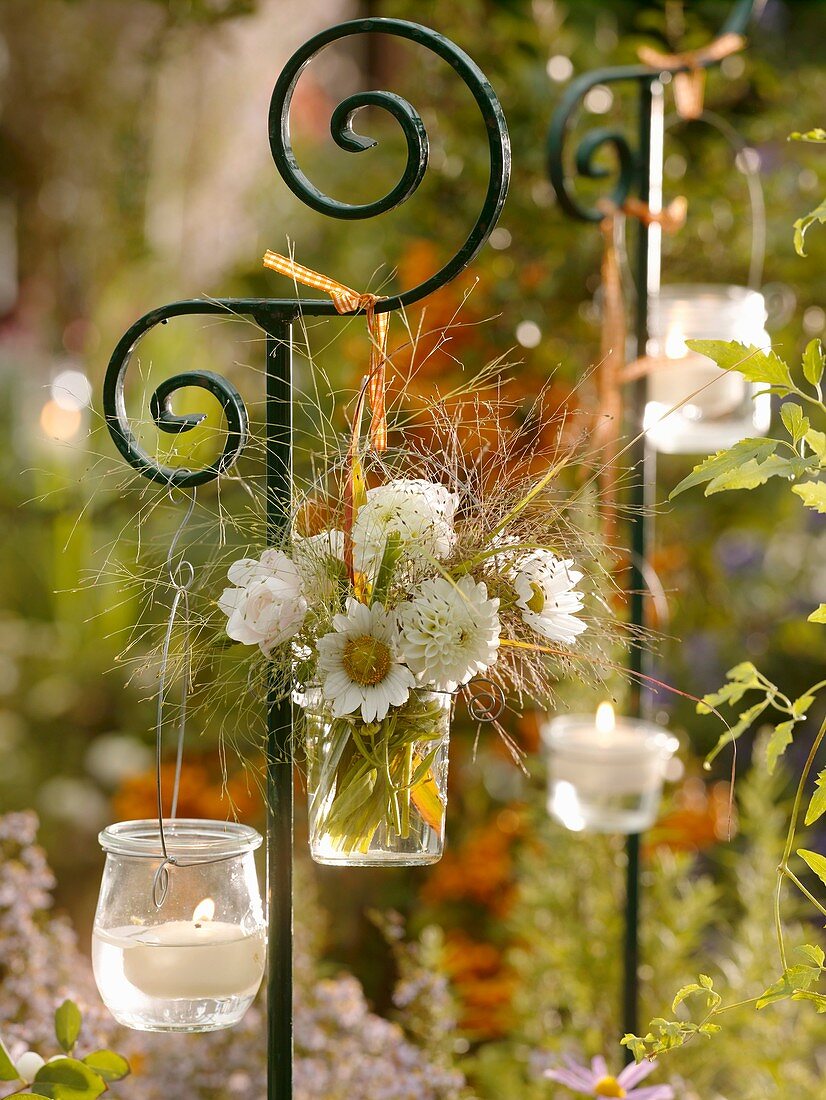 Blumenstrauss in Vase und Windlichter an Dekostab aufgehängt