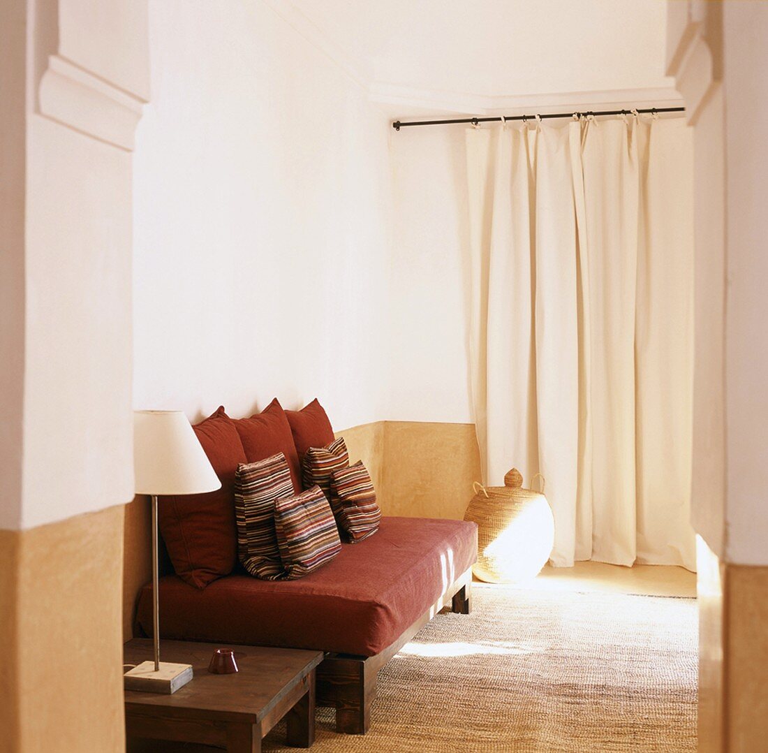 Sitzecke im modernen, orientalischen Stil mit Kissen auf einem Matratzensofa