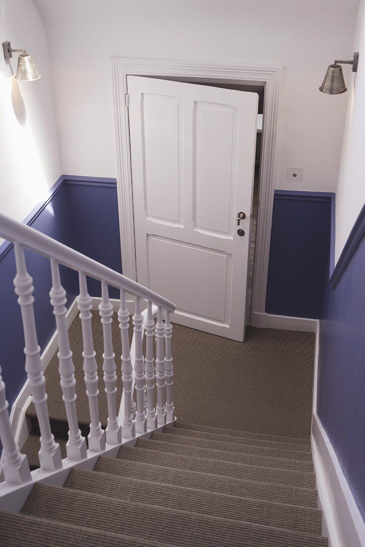 Modern, renovated, country-house staircase with sisal carpet and dado painted lavender blue