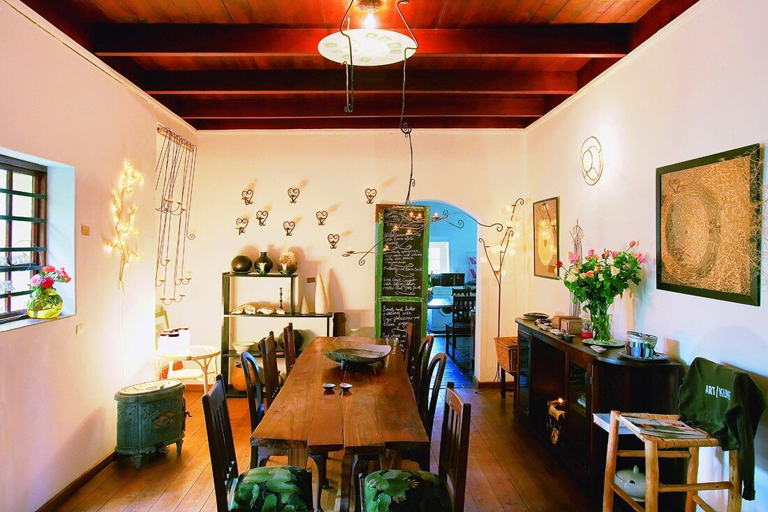 Prettily decorated dining room with rustic table and ruddy wooden ceiling