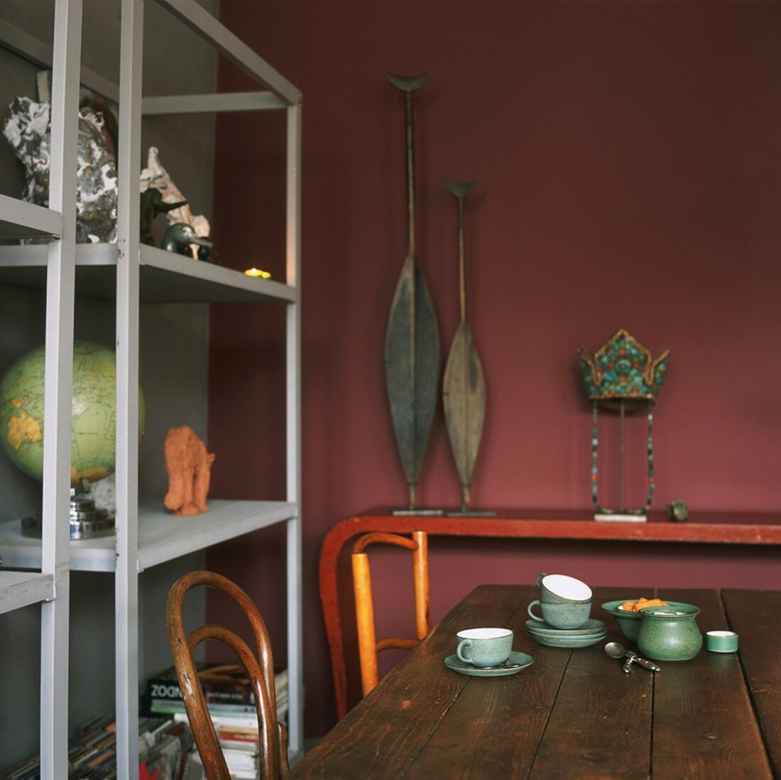 Ausschnitt eines Esszimmers mit rustikalem Holztisch und einfachen Holzregalen