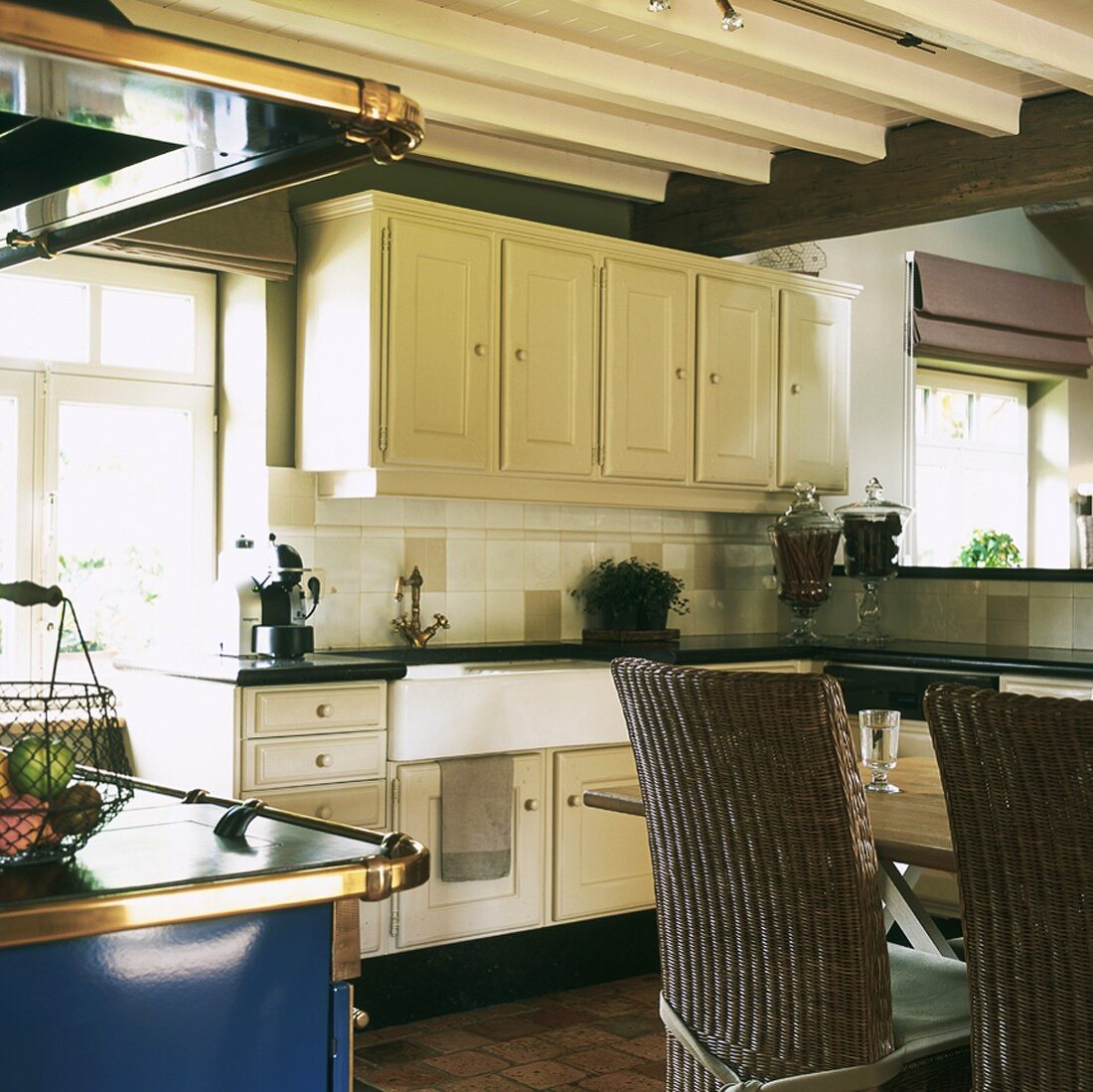 Open-plan kitchen with dining table and wicker chairs