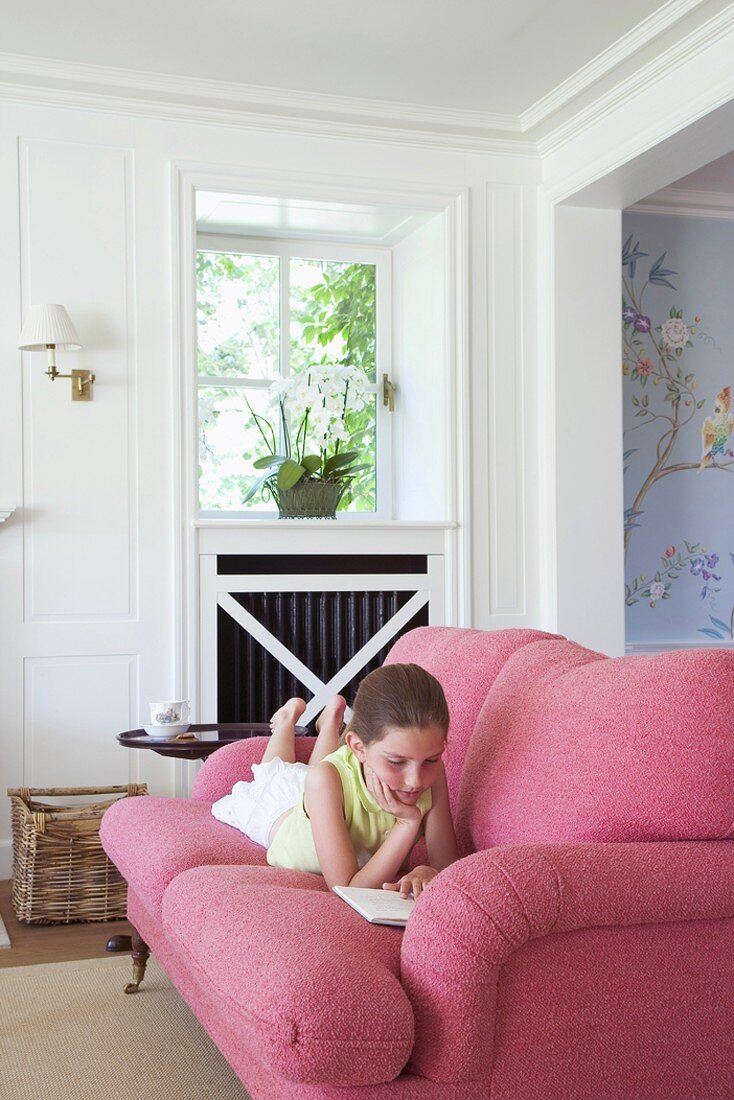 Lesendes Mädchen auf gemütlichem Sofa