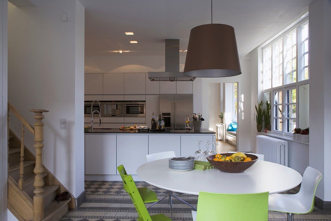 Open-plan dining area with foot of staircase and view into kitchen area