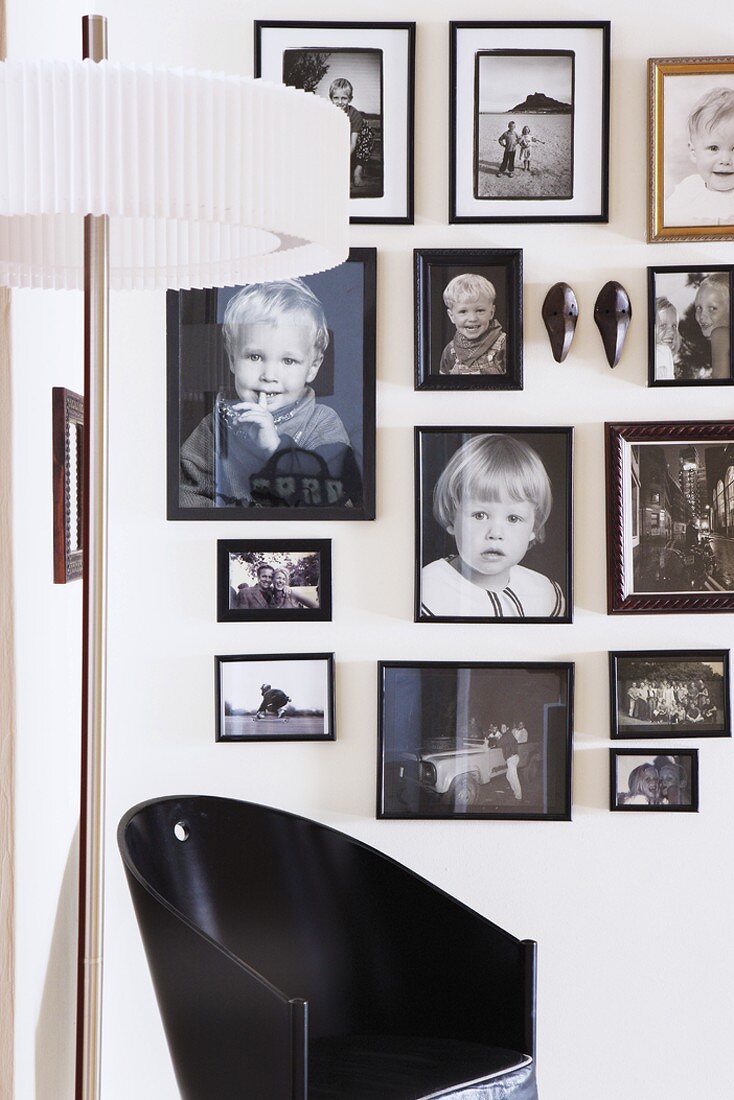Schwarzer Stuhl unter einer schwarz-weiss Fotosammlung