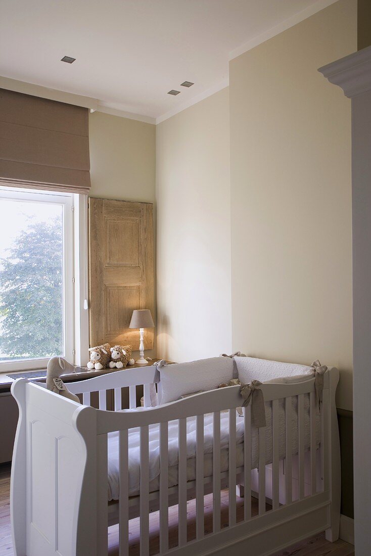 Nursery with white cot and view of tree
