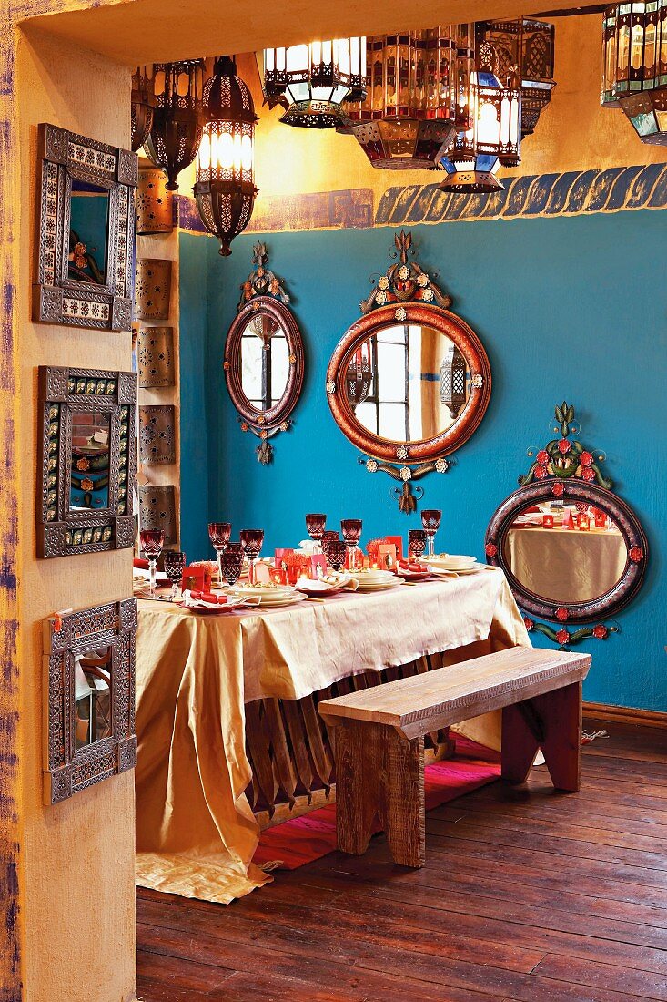 Esszimmer mit festlich gedecktem Tisch und Wandspiegeln