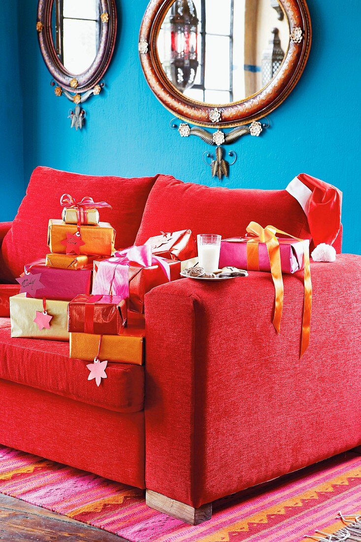 Weihnachtsgeschenke auf einem roten Sofa
