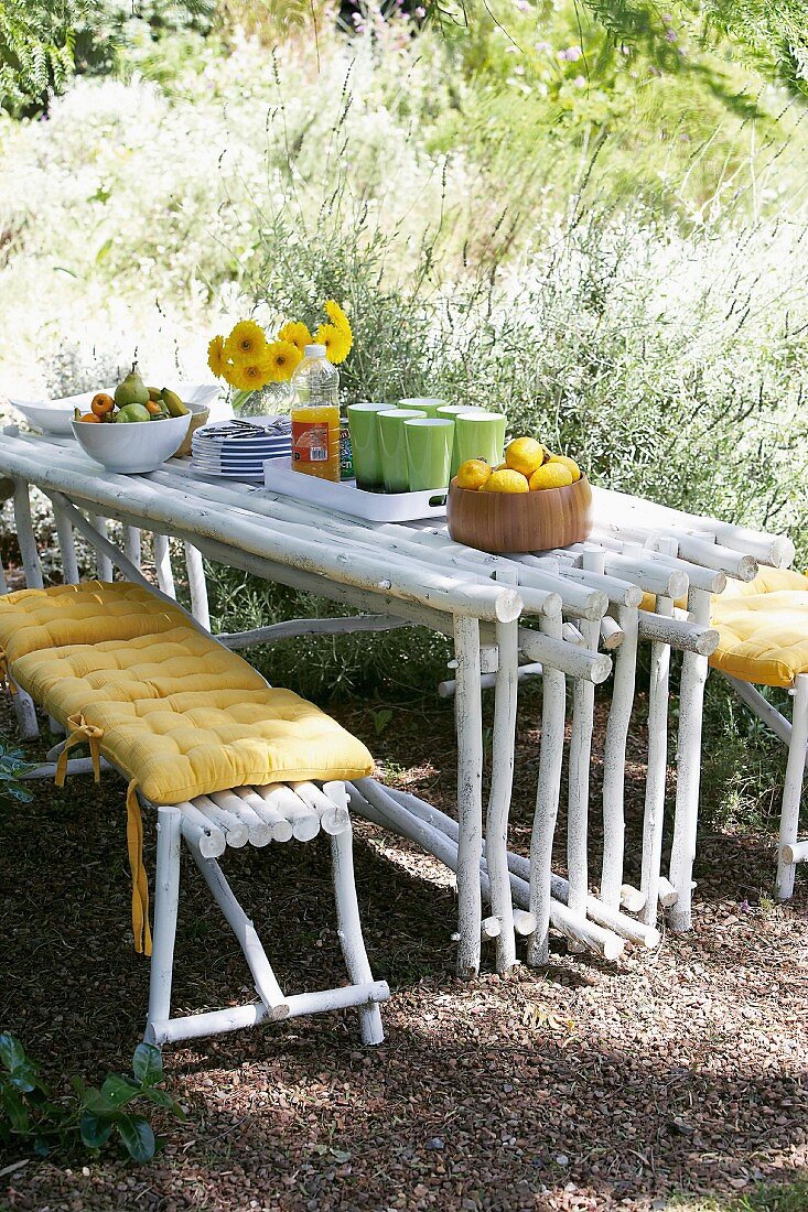 Picknicken im Freien - gedeckter selbstgebauter Tisch aus Holzstäben