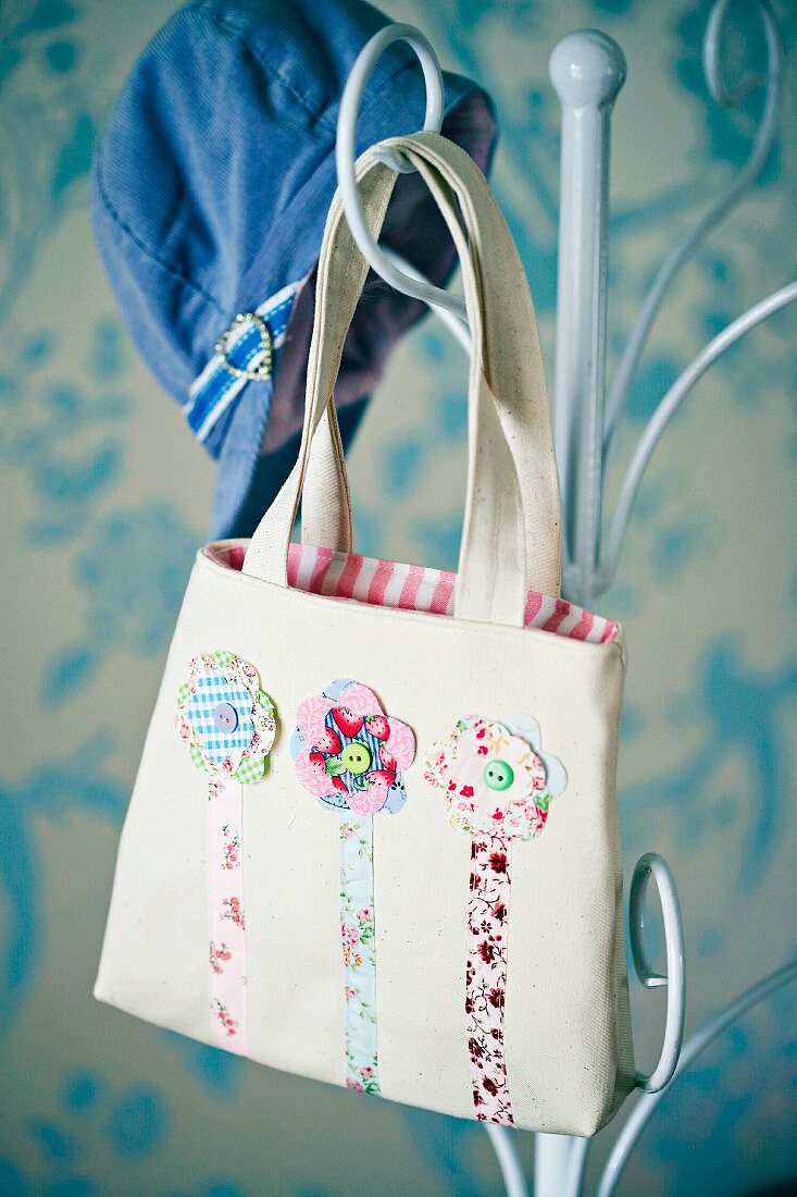 Mädchentasche mit Blumenmotiven an Garderobenständer aus Metall